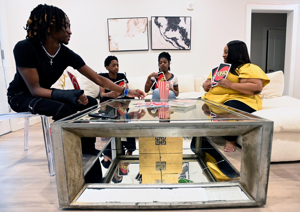 Eric Fitih, left, Ethan Fitih and Jada Fitih play a card game with their mother, Samantha Sharpe, before dinner at their home on Friday, March 22, 2024, in Nashville, Tenn.