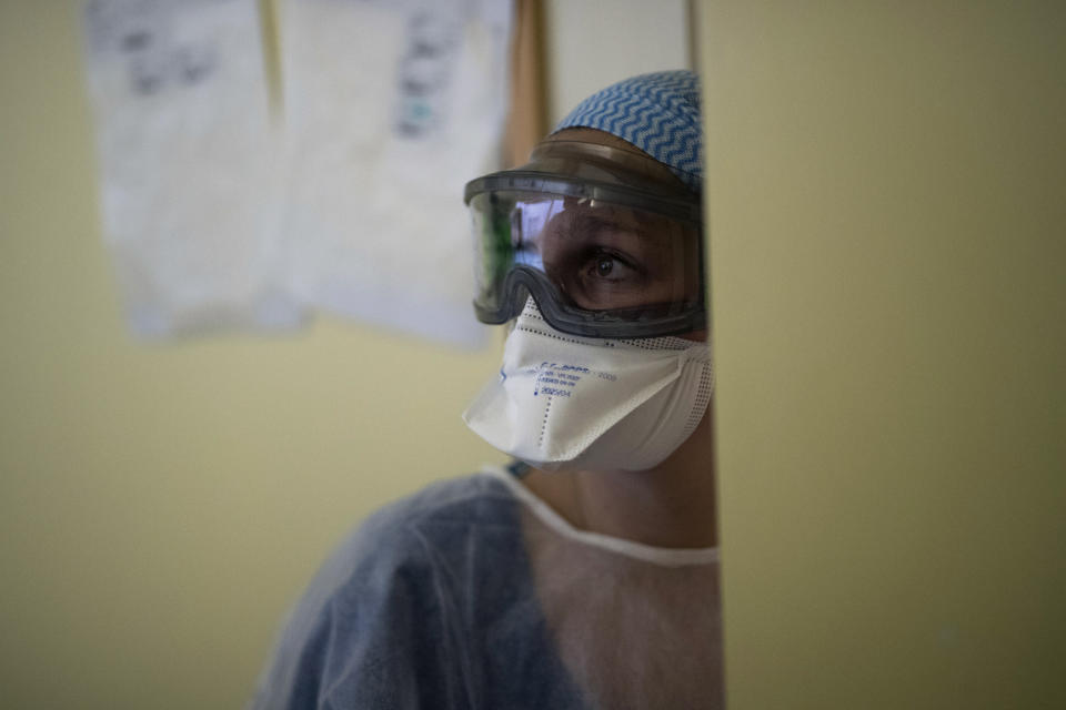 A nurse turns around to check the vitals of a patient suffering from COVID-19 in the ICU at the La Timone hospital in Marseille, southern France, Tuesday Feb. 2, 2021. COVID patients occupy 88% of the Marseille region's intensive care beds, and virus pressure on French hospitals is steadily rising in recent weeks despite curfews and other restrictions. (AP Photo/Daniel Cole)