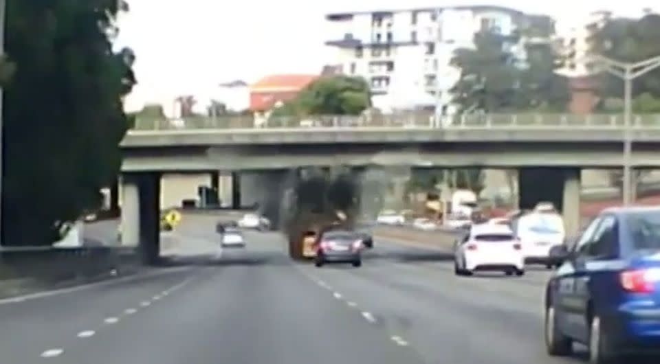 The truck smashes into the overpass with a car close behind. Source: 7 News