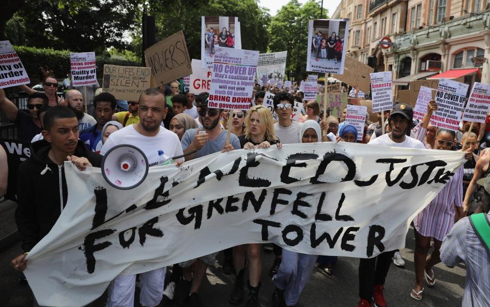 Protesters hold signs calling for 'justice' - Credit: Dan Kitwood/Getty