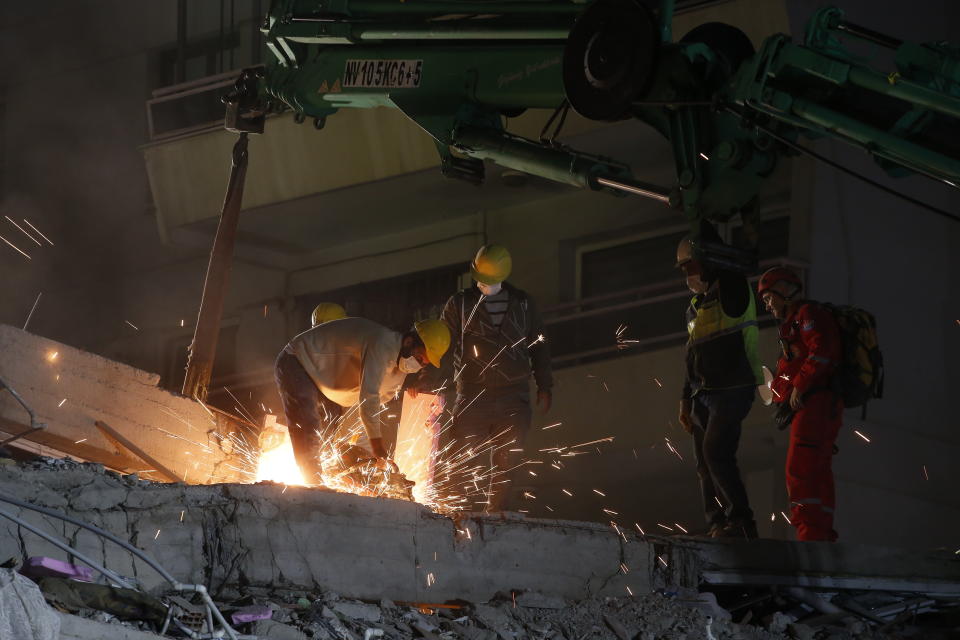 Members of rescue services cut cement and iron as they search in the debris of a collapsed building for survivors in Izmir, Turkey, early Saturday, Oct. 31, 2020. A strong earthquake struck Friday in the Aegean Sea between the Turkish coast and the Greek island of Samos, killing several people and injuring hundreds amid collapsed buildings and flooding. (AP Photo/Emrah Gurel)