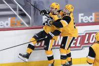 Pittsburgh Penguins' Mark Friedman, left, celebrates with Jake Guentzel after his first NHL goal, during the first period of the team's hockey game against the Philadelphia Flyers, Thursday, March 4, 2021, in Pittsburgh. (AP Photo/Keith Srakocic)