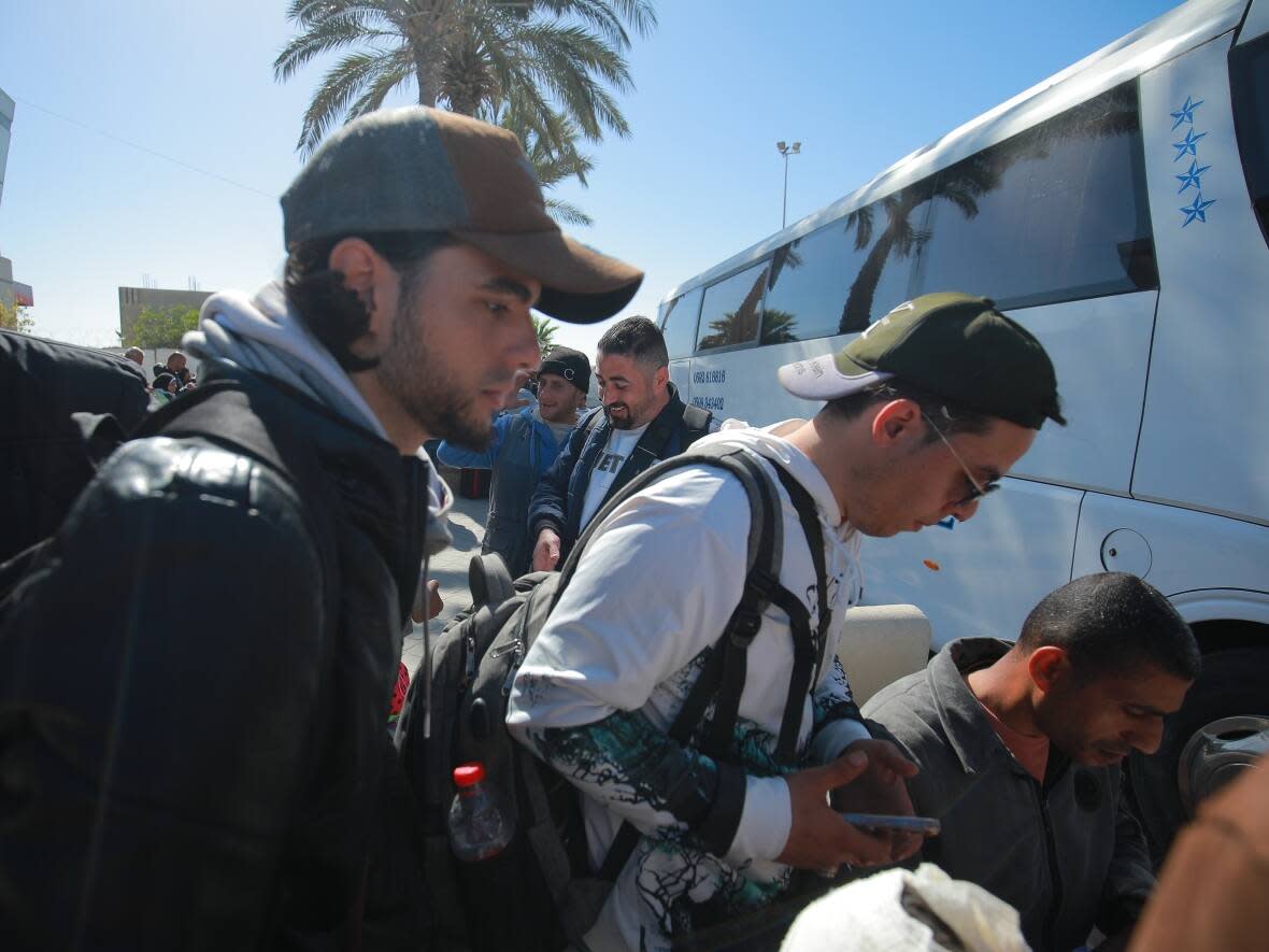 Abdelrahman Kouta, left, and Mahmoud Kouta, right, board a bus from Rafah to Cairo on March 12, 2024. (Mohamed El Saife/CBC - image credit)