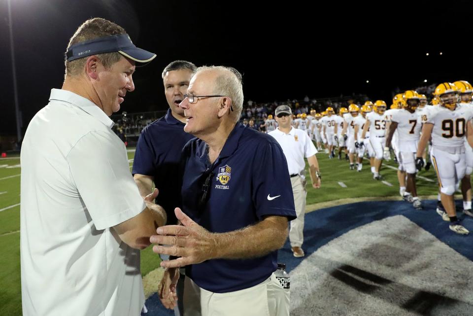 St. Ignatius football coach Chuck Kyle, right, shakes hands with Tim Tyrrell, head coach of the Archbishop Hoban football team, following the Wildcats' 28-7 loss to Tyrell's Knights, Friday, Sept. 16, 2022, in Akron. Kyle is retiring at the end of the season after serving as St. Ignatius' head coach for 40 years.