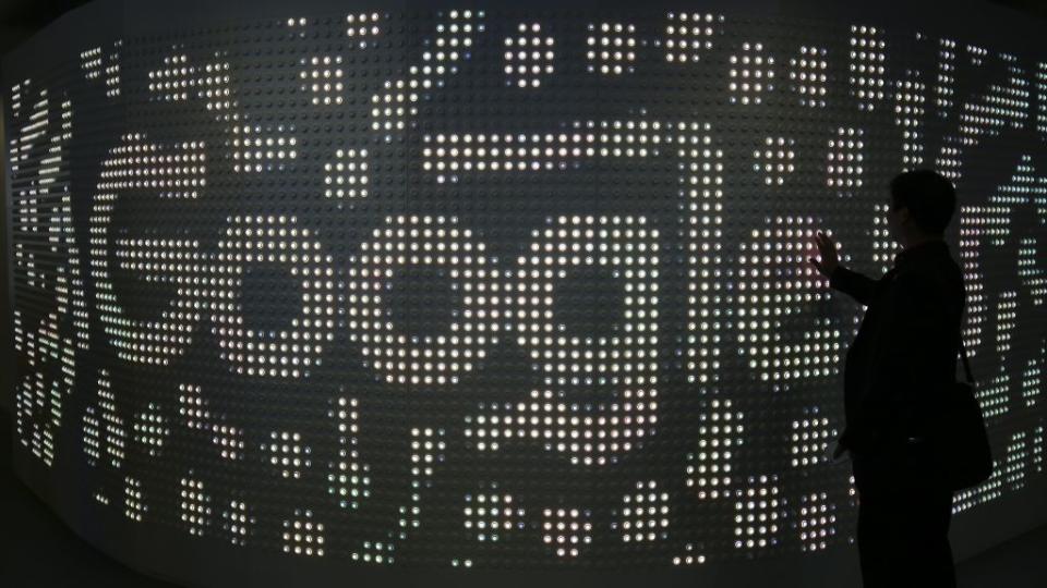 An attendee interacts with an illuminated panel at Google stand during the Mobile World Congress in Barcelona