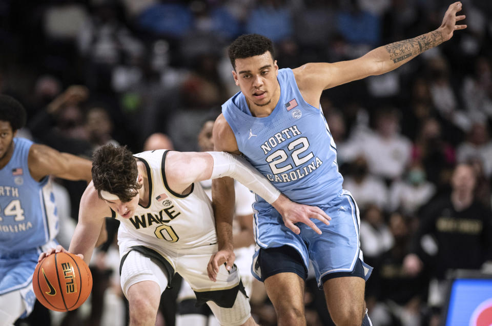 Wake Forest forward Jake Laravia (0) dribbles up the court with pressure from North Carolina forward Justin McKoy (22) during the first half of an NCAA college basketball game Saturday, Jan. 22, 2022, in Winston-Salem, N.C. (Allison Lee Isley/The Winston-Salem Journal via AP)