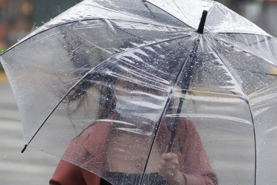 A woman struggles with her umbrella against powerful gusts of wind generated by Typhoon Chanthu in Taipei, Taiwan, Sunday, Sept. 12, 2021. Typhoon Chanthu drenched Taiwan with heavy rain Sunday as the storm’s center passed the island’s east coast heading for Shanghai. (AP Photo/Chiang Ying-ying)