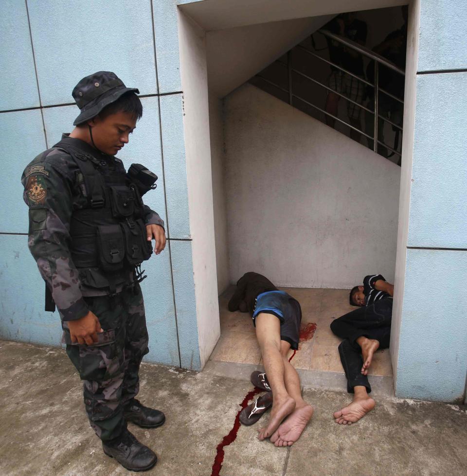 A policeman guards Moro National Liberation Front rebels captured at a police checkpoint in downtown Zamboanga