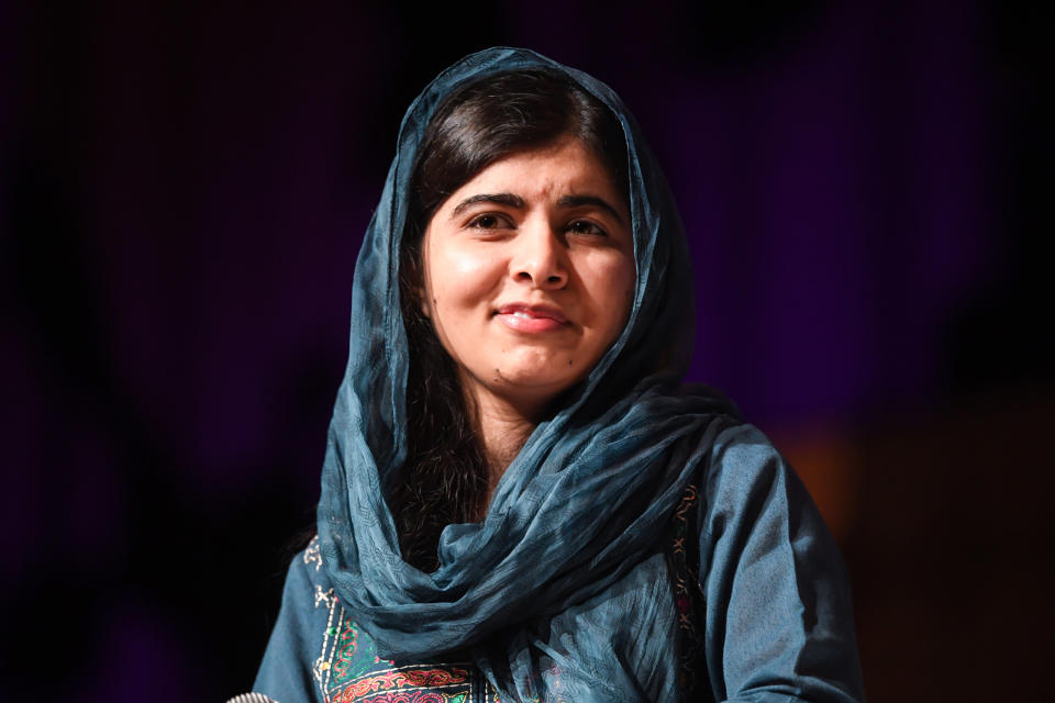 Malala smiles while speaking on stage