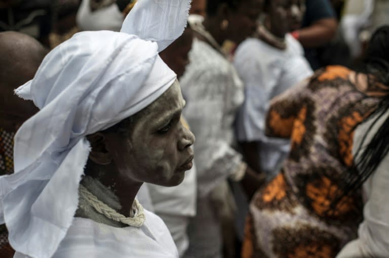 A devotee of Osun, the goddess of water and fertility, makes her way to the river to offer prayers and sacrifices