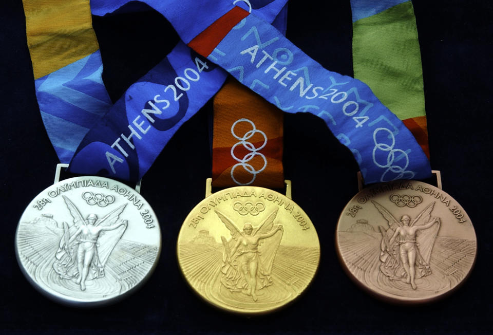 FILE - The silver, left, the gold, center, and the bronze Olympic medals of the Aug. 13-29 Olympics are seen in Aspropyrgos, near Athens on Monday, July 26, 2004. (AP Photo/Petros Giannakouris, File)