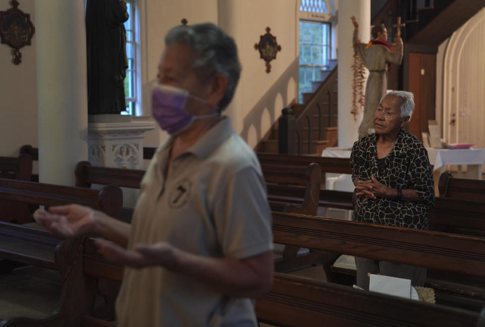 Sister Alicia Damien Lau, left, Meli Watanuki, stand to pray during Mass on Wednesday, July 19, 2023, in Kalaupapa, Hawaii. In the 1800s, Kalaupapa was a settlement for banished leprosy patients, later called Hansen's disease. It's now a refuge for the eight former patients, including Watanuki. (AP Photo/Jessie Wardarski)