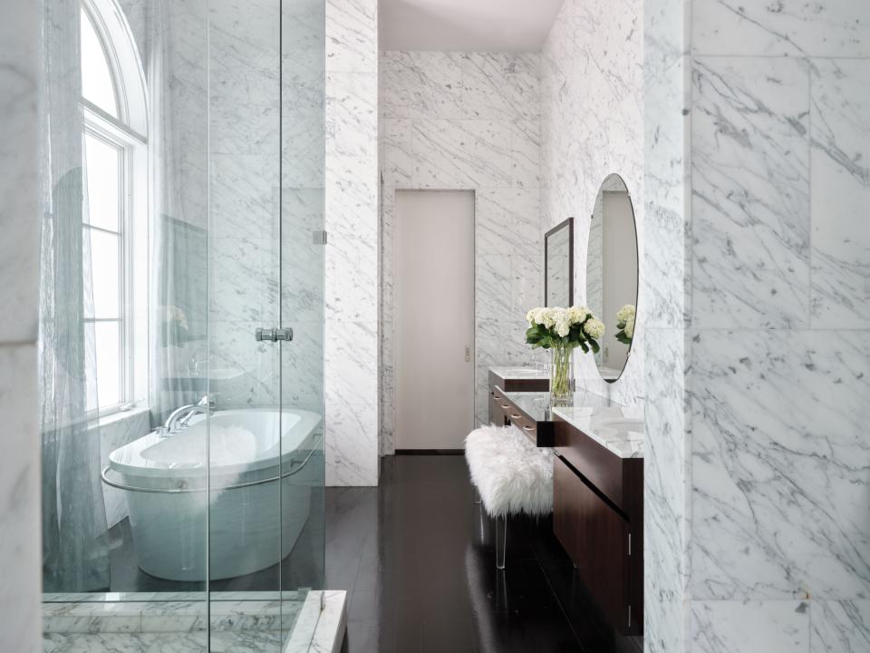 Clad from floor to ceiling in Carrara marble, the guest bath offers quite the self-care respite for overnight guests.