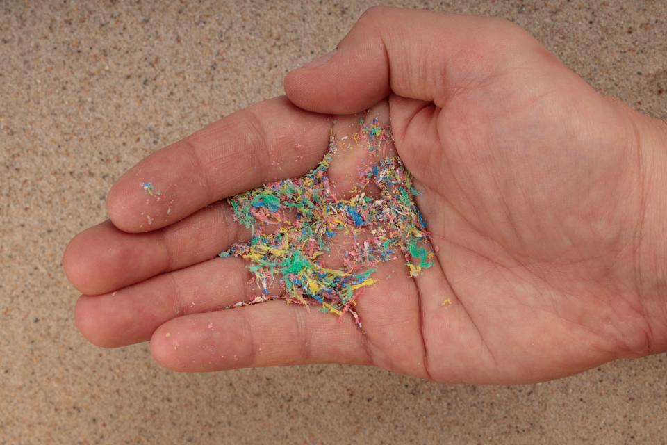 A handful of microplastics on hand, an ecological concept. Environmental pollution.