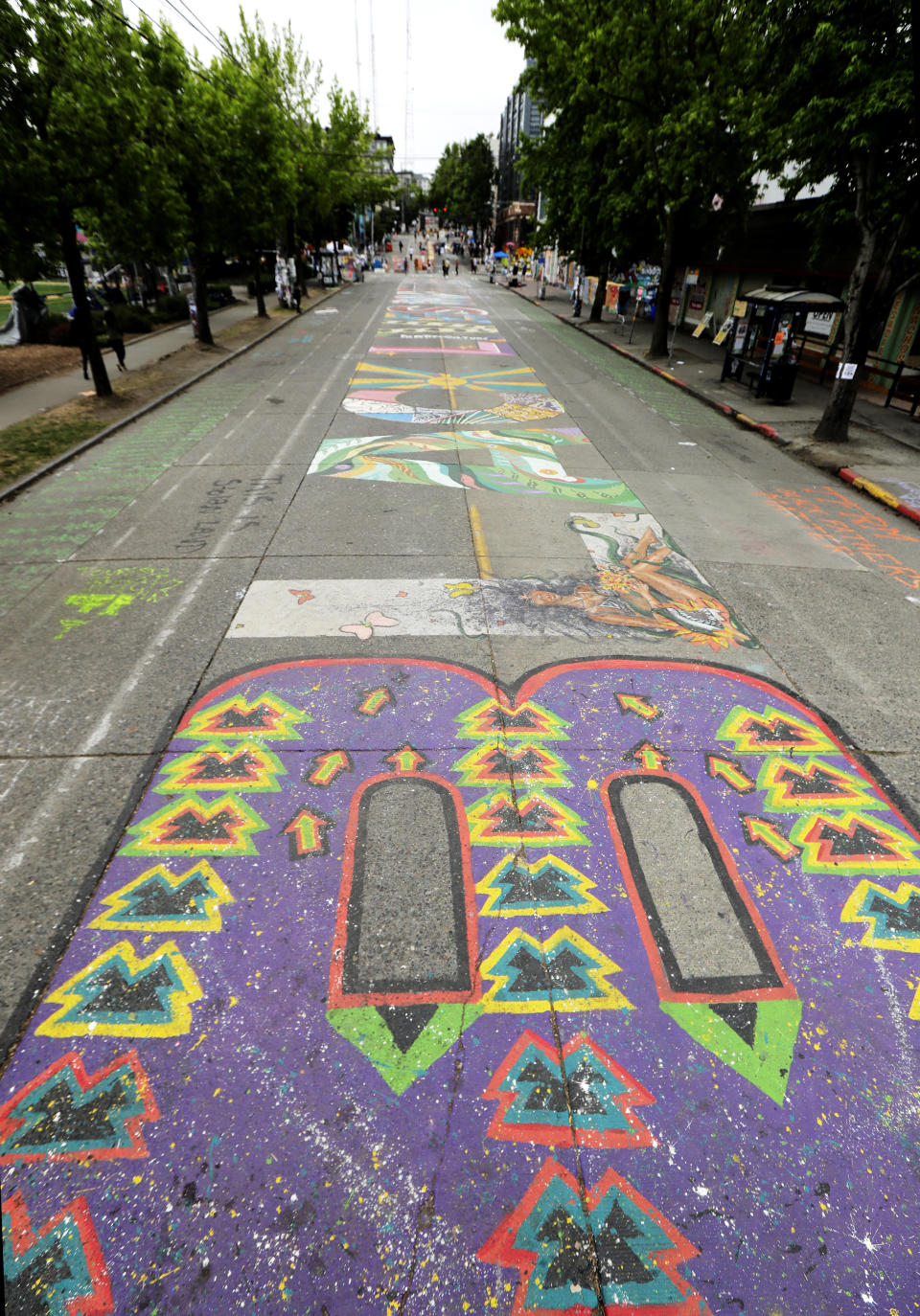 The words "Black Lives Matter" are shown painted on Pine St., Wednesday, June 24, 2020, inside the CHOP (Capitol Hill Occupied Protest) zone in Seattle. The area has been occupied since a police station was largely abandoned after clashes with protesters, but Seattle Mayor Jenny Durkan said Monday that the city would move to wind down the protest zone following several nearby shootings and other incidents that have distracted from changes sought peaceful protesters opposing racial inequity and police brutality. (AP Photo/Ted S. Warren)