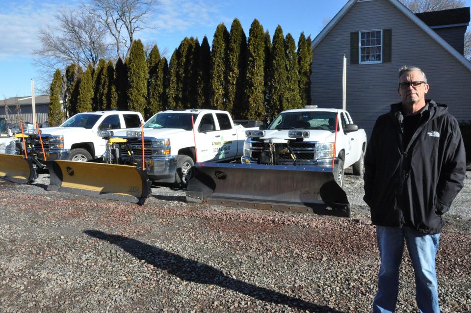 Kevin Patterson, owner of A-1 Kevin's Landscaping in Smyrna, stands in front of trucks with snow plows Jan. 20, 2023. He  said he can only remember one other winter with as little snow as this one so far in his 37 years in business, but the mild weather has allowed him to work on more landscaping projects than usual.