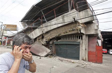 A resident walks past a building collapsed during an earthquake in Cebu city, central Philippines October 15, 2013. REUTERS/Stringer