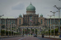 Motorists drive in front of the prime minister's office building in Putrajaya, Malaysia, Friday, Oct. 23, 2020. Malaysian opposition leader Anwar Ibrahim said Friday he was concerned about reports that Prime Minister Muhyiddin Yassi may invoke emergency laws to suspend Parliament and stymie bids to oust his government. (AP Photo/Vincent Thian)