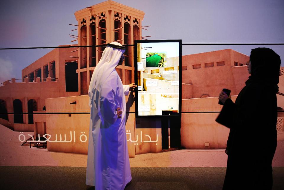 Emirati government employees use a touch-screen display on a wall in Dubai, United Arab Emirates, Wednesday, March 5, 2014. After years of chasing the biggest and the best, the fast-growing Mideast city of Dubai is turning to technology to help the little things in life run more smoothly. (AP Photo/Kamran Jebreili)