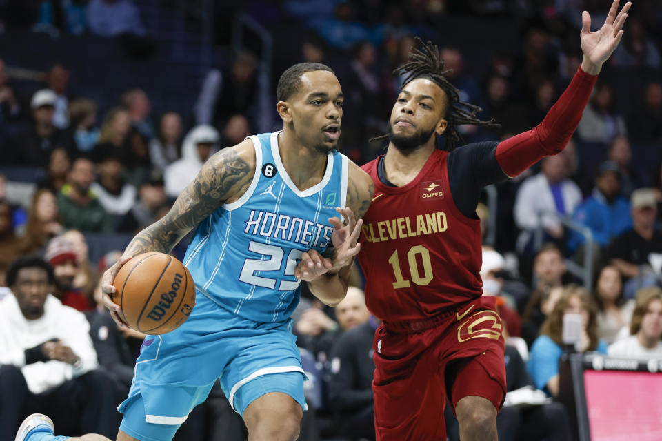 Charlotte Hornets forward P.J. Washington (25) drives against Cleveland Cavaliers guard Darius Garland (10) during the first half of an NBA basketball game in Charlotte, N.C., Sunday, March 12, 2023. (AP Photo/Nell Redmond)