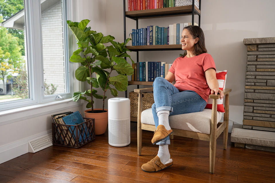 Woman sitting in a chair and enjoying cleaner indoor air thanks to air purifier from Canadian Tire