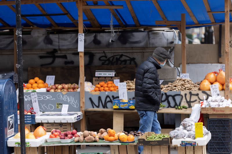 A person walks past a stall selling fruit and vegetables in Manhattan, New York City