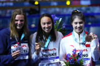 Silver medalist Marie Wattel of France, gold medalist Torri Huske of the United States and bronze medalist Zhang Yufei of China, from left to right, pose after competing in the Women 100m Butterfly final at the 19th FINA World Championships in Budapest, Hungary, Sunday, June 19, 2022. (AP Photo/Petr David Josek)