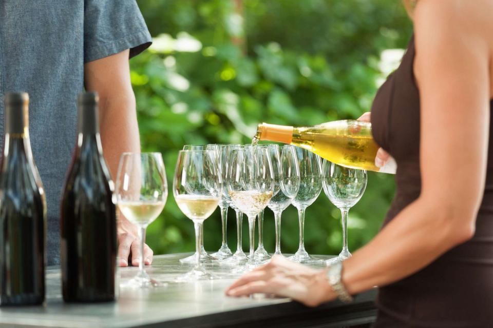 PHOTO: In an undated stock photo, a bartender pours white wine from a wine bottle into wine glasses for outdoor wine tasting in Napa Valley, Calif. (STOCK PHOTO/Getty Images)