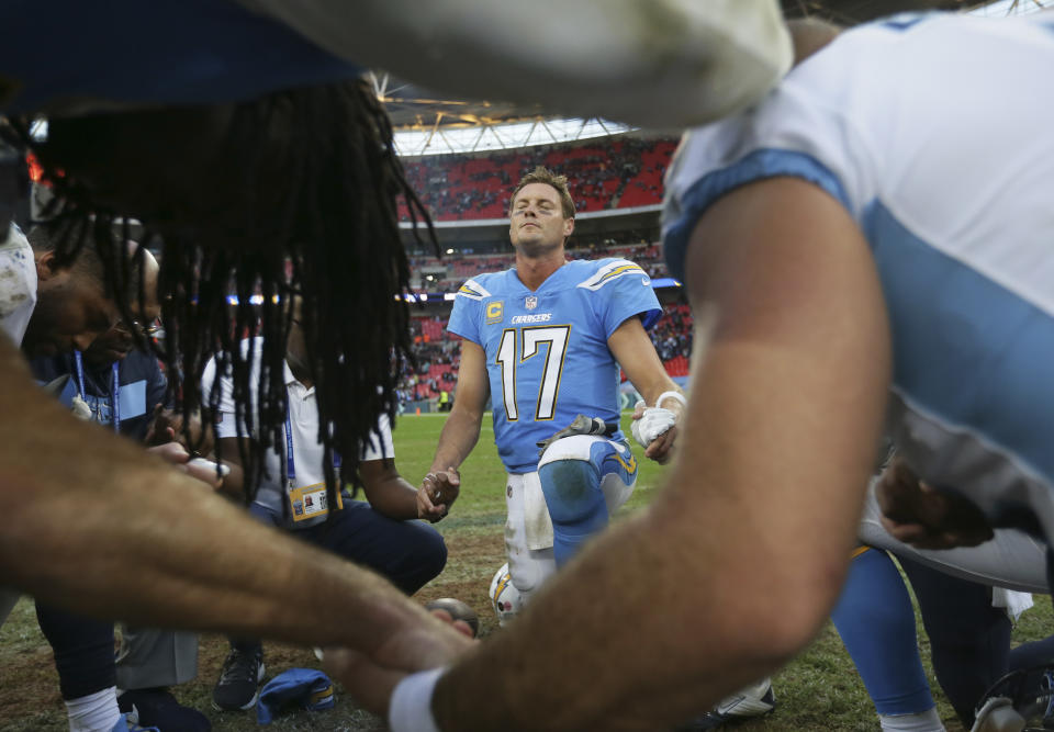Los Angeles Chargers quarterback Philip Rivers (17) joins other players in prayer after an NFL football game against Tennessee Titans at Wembley stadium in London, Sunday, Oct. 21, 2018. Los Angeles Chargers won the match 20-19. (AP Photo/Tim Ireland)