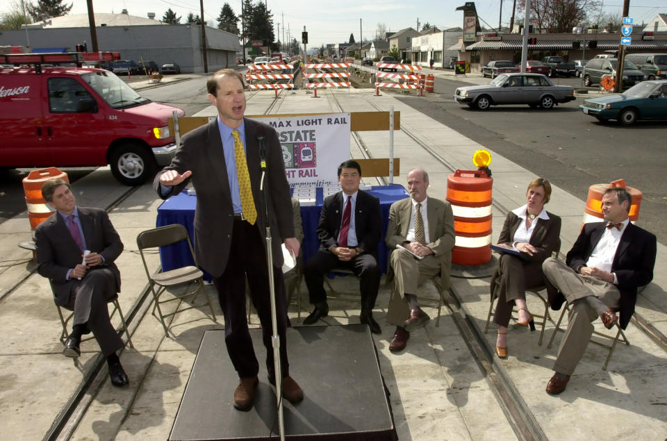 FILE - Sen. Ron Wyden, D-Ore., speaks at a ceremony to celebrate the 50% completion mark of the Interstate Max line in north Portland, Ore., Tuesday, April 2, 2002. Seated behind Wyden are, from left, Sen. Gordon Smith, R-Ore., Rep. David Wu, D-Ore., Metro executive officer Mike Burton, Federal Transit Administrator Jenna Dorn and Rep. Earl Blumenauer, D-Ore. (AP Photo/Greg Wahl-Stephens, File)
