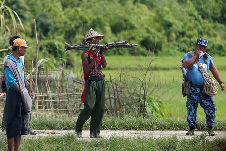 FILE PHOTO: A Myanmar soldier (C) and a policeman patrol a road in Maungdaw, Myanmar, August 31, 2017. REUTERS/Soe Zeya Tun/File Photo