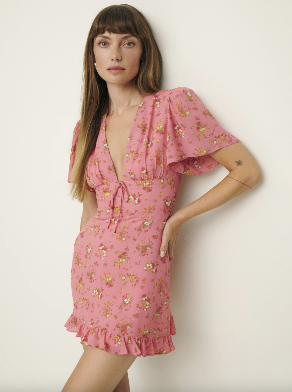 model wearing pink floral reformation mini dress, Mya Dress (Photo via Reformation)