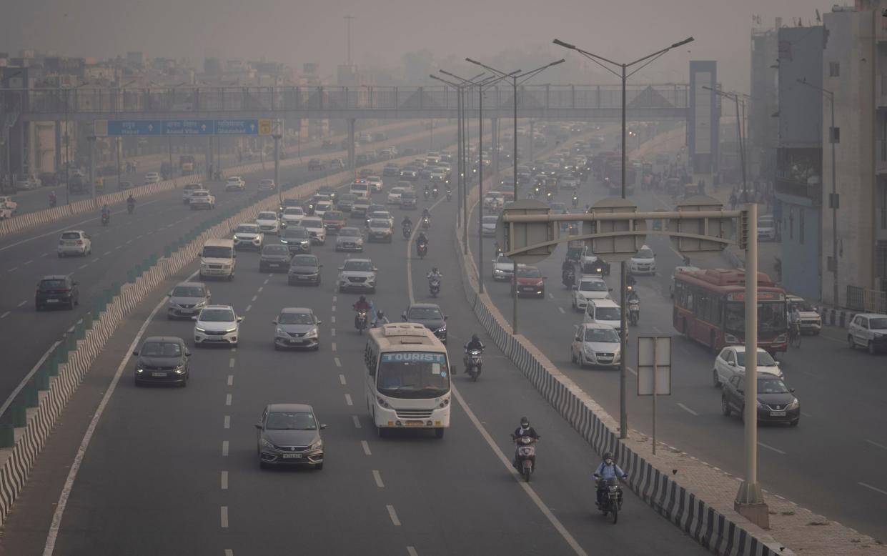 Motorcyclists drive wearing pollution masks amid smog in New Delhi, India