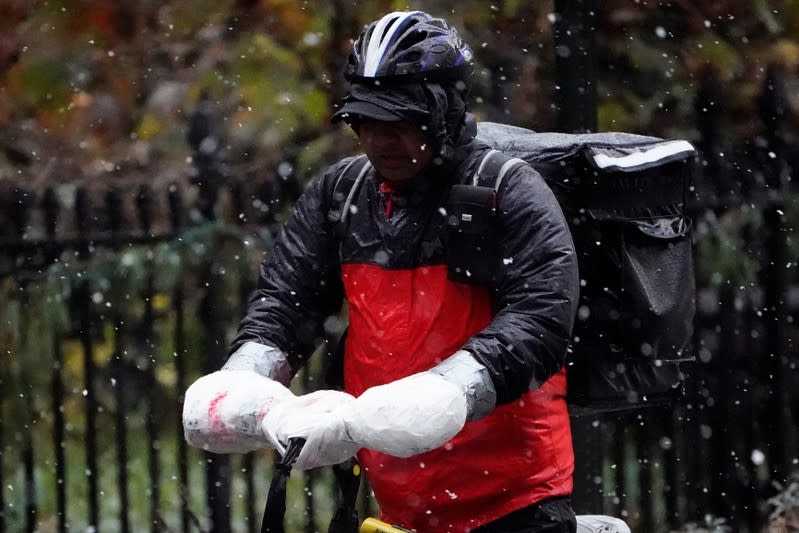 A delivery person rides his bike in the snow in the Manhattan borough of New York City