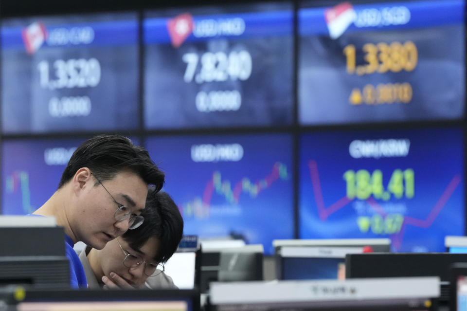 FILE - Currency traders work at the foreign exchange dealing room of the KEB Hana Bank headquarters in Seoul, South Korea, March 7, 2024. Asian markets were mostly higher Wednesday, March 20, 2024 ahead of expected guidance by the Federal Reserve on the timing of its cuts to interest rates. (AP Photo/Ahn Young-joon, File)