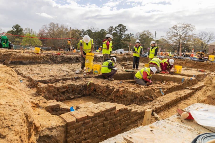 Colonial Williamsburg Archaeology staff investigates remains of 18th Century house at future Campbell Archaeology Center site. Staff works at house site.