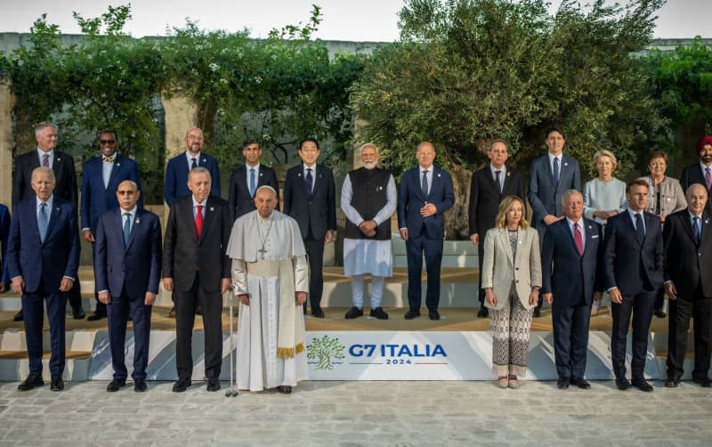 Pope Francis stands between Heads of state of the G7 countries and heads of government of the guest countries at the family photo after the meeting of the G7 and outreach guests at the G7 summit. Michael Kappeler/dpa