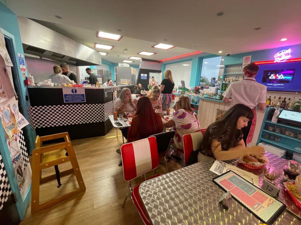 A view of the bar, open kitchen and tables at Karen's Diner