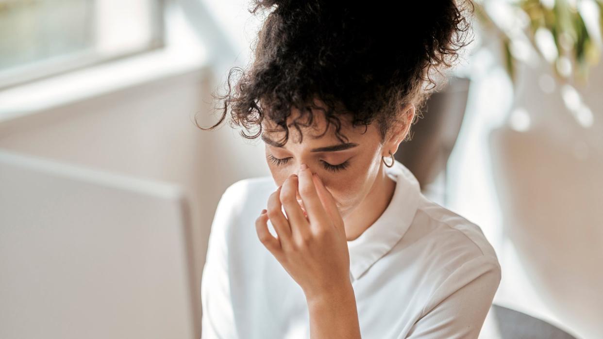 Burnout, stress and business woman in office feeling pain, exhausted or migraine. Headache, mental health and anxiety of tired female employee overworked, stressed and depressed in company workplace.