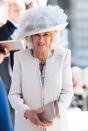 <p>Camilla wore this foggy gray and cream hat, bow brooch, and cream colored coat with pearl edging to an event for the Victoria Cross and George Cross Association in London, England.</p>