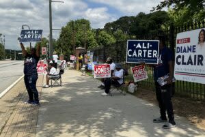  Sign wavers stood outside a west Atlanta polling place Tuesday trying to convince passing motorists to stop and vote. Jill Nolin/Georgia Recorder