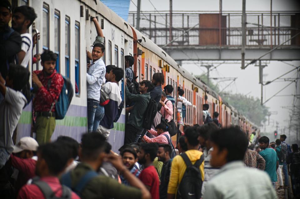 People board an overcrowded train at a railway station on the outskirts of New Delhi, India. <a href="https://www.gettyimages.com/detail/news-photo/people-board-an-overcrowded-train-at-a-railway-station-in-news-photo/1252255086?adppopup=true" rel="nofollow noopener" target="_blank" data-ylk="slk:Kabir Jhangiani/NurPhoto via Getty Images;elm:context_link;itc:0;sec:content-canvas" class="link ">Kabir Jhangiani/NurPhoto via Getty Images</a>