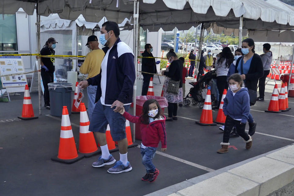 FILE - In this Jan. 7, 2021, file photo, people walk to a tent at a COVID-19 walk-up testing site on the Martin Luther King Jr. Medical Campus in Los Angeles, Jan. 7, 2021. Coronavirus deaths and cases per day in the U.S. dropped markedly over the past couple of weeks but are still running at alarmingly high levels, and the effort to snuff out COVID-19 is becoming an ever more urgent race between the vaccine and the mutating virus. (AP Photo/Marcio Jose Sanchez, File)