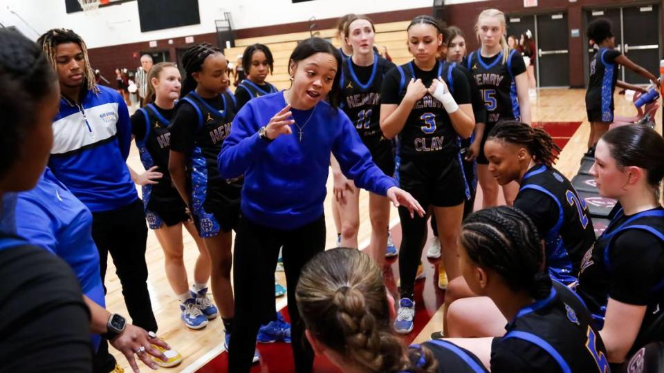 Henry Clay coach Ashley Garrard, center, spoke to her team at a timeout during the Blue Devils 54-47 win over the Commodores in the girls 11th Region Tournament quarterfinals at Tates Creek High School on Monday.