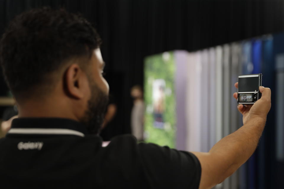 A person takes a selfie with the Samsung Galaxy Flip 3 on Monday, Aug. 9, 2021, at Samsung KX in London. Samsung is hoping cheaper but more durable versions of its foldable phones will broaden the appeal of a high-concept design that’s so far fizzled with consumers. (AP Photo/Tristan Werkmeister)