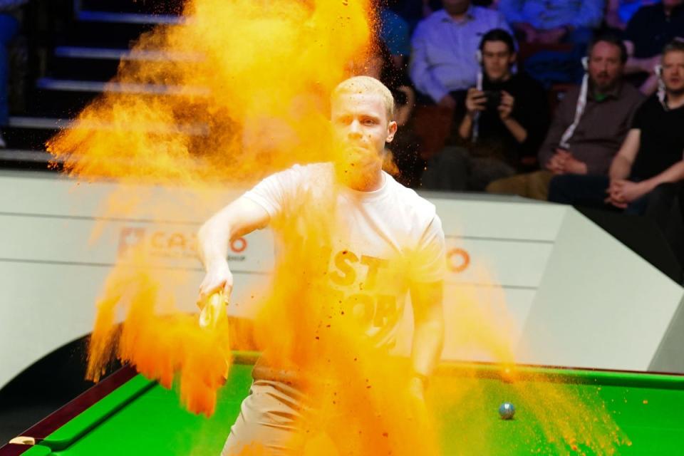 Just Stop Oil protester Edred Whittingham, known as Eddie, jumps on the table and throws orange powder (PA Wire)