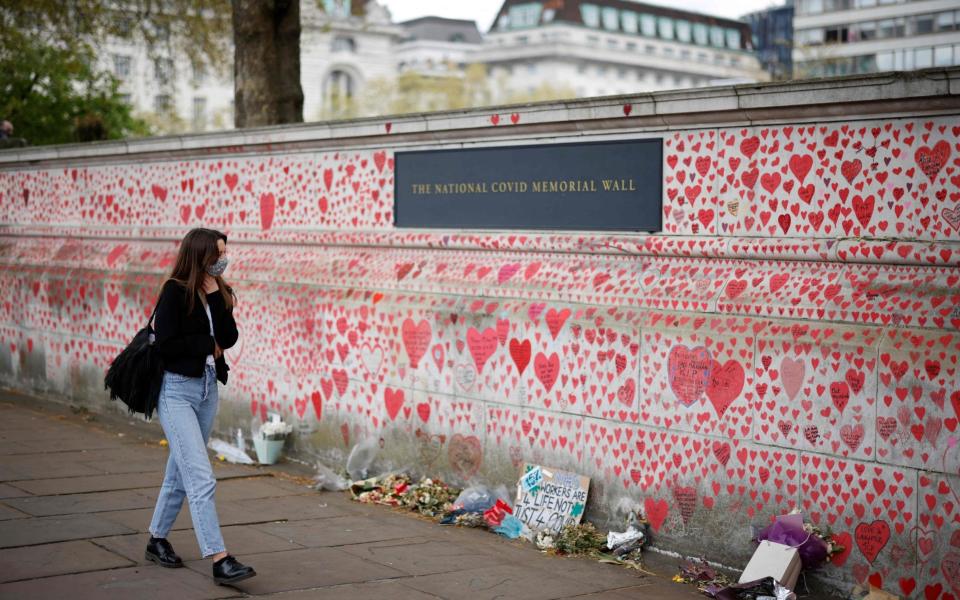 A woman looks at the hearts and messages on the National Covid Memorial Wall on the embankment - TOLGA AKMEN/AFP