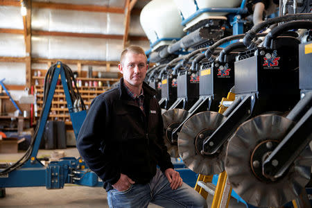 Soybean farmer Austin Rincker poses for a photograph near his planter equipment at his farm in Moweaqua, Illinois, U.S., March 6, 2019. Rincker will farm approximately 2500 acres in the upcoming season, split evenly between corn and soybeans. Picture taken March 6, 2019. REUTERS/Daniel Acker