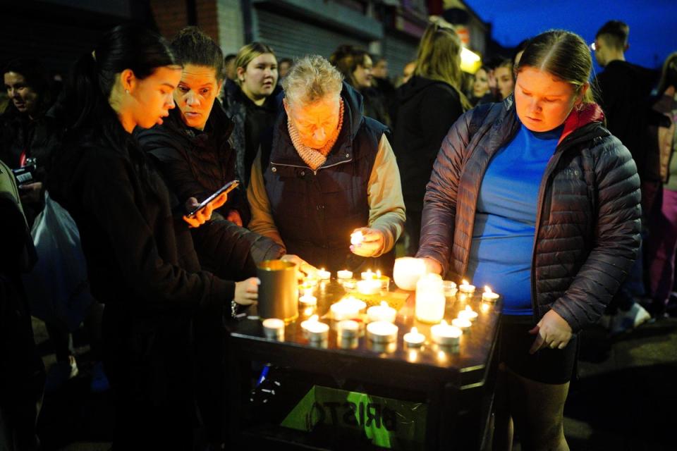 People take part in a vigil near to the scene in south Bristol (PA)