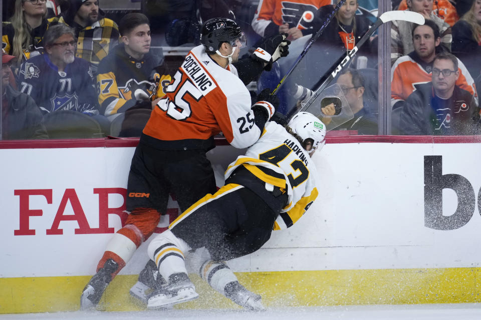 Philadelphia Flyers' Ryan Poehling, left, and Pittsburgh Penguins' Jansen Harkins collide during the first period of an NHL hockey game, Monday, Dec. 4, 2023, in Philadelphia. (AP Photo/Matt Slocum)